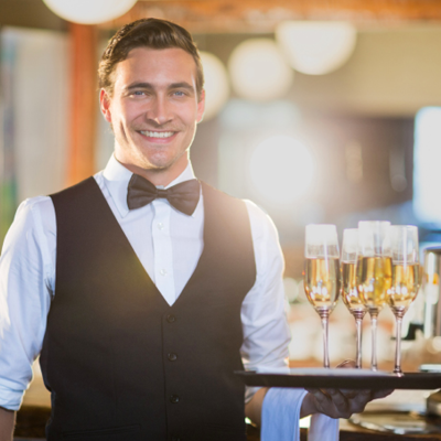 Servicekraft Catering mit Serviertablett und Sektgläsern mit Champagner