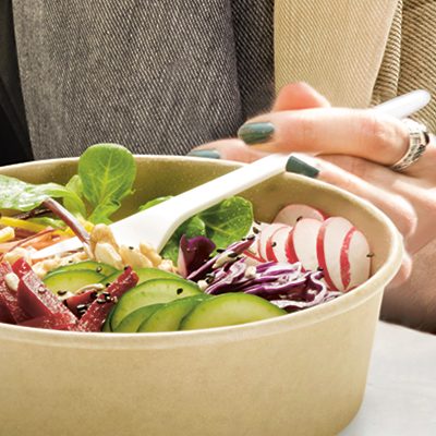 Hand mit Gabel und Salatschale von naturesse