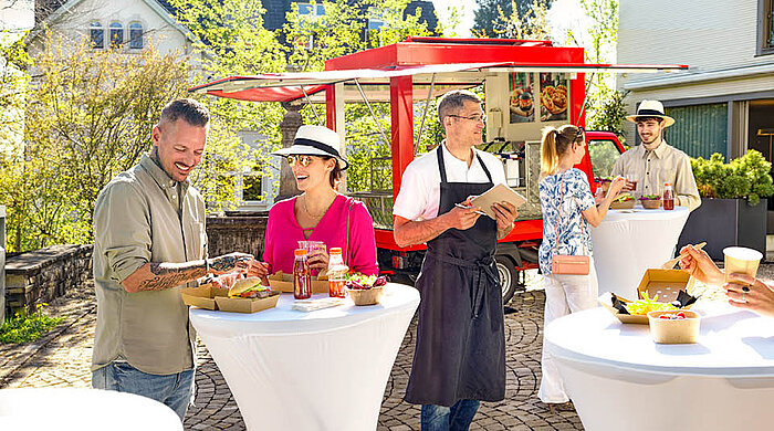 Food-Truck-Mitarbeiter bedient Kunden mit Speisen und Getränken in Pacovis-Geschirr